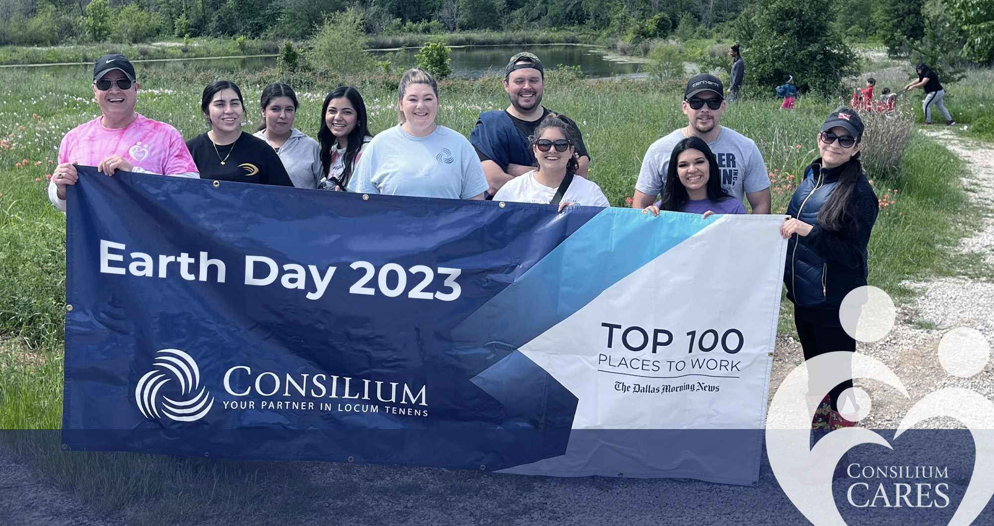 A team from Consilium posing with an earth day flag.