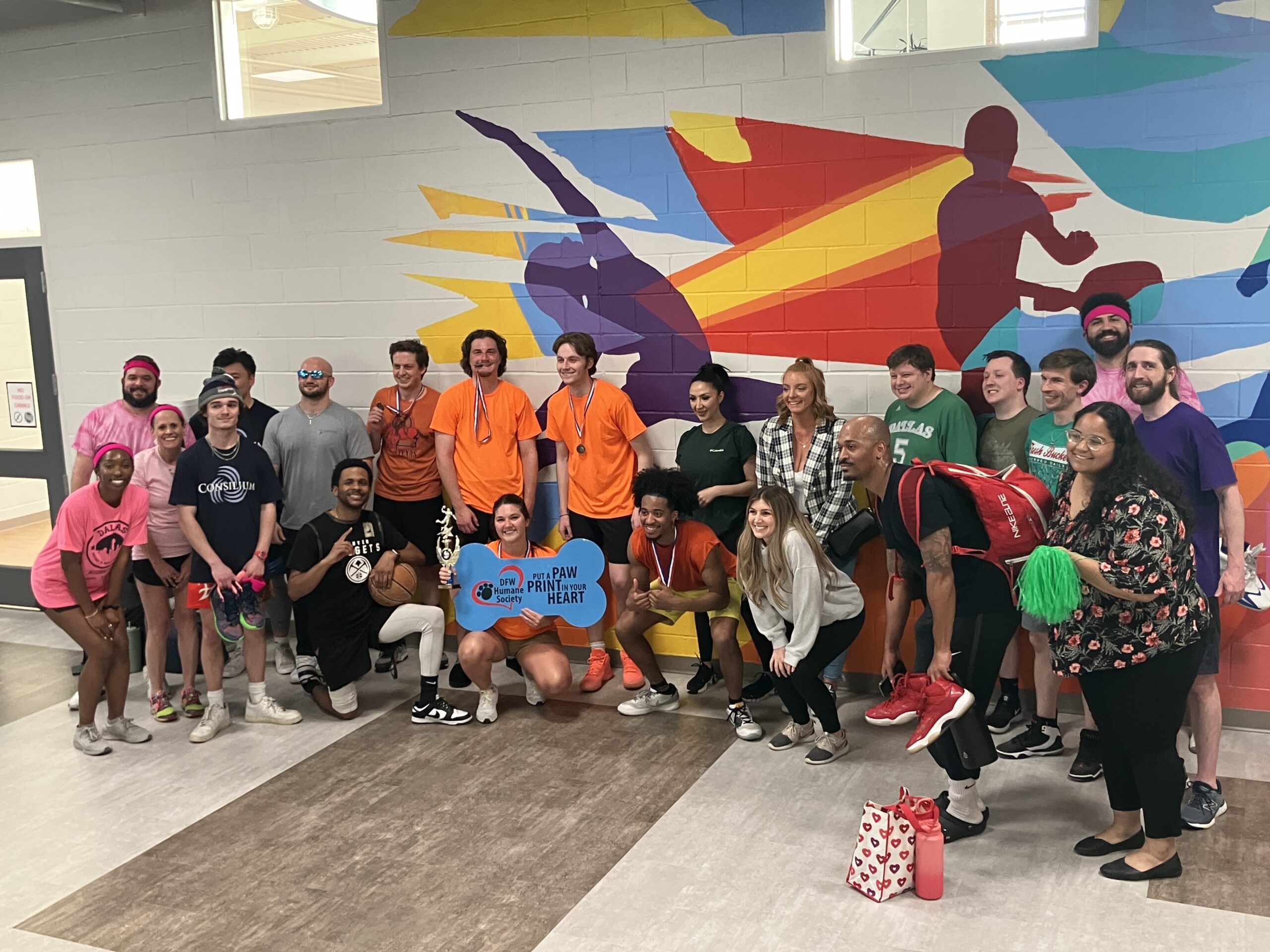 An array of Consilium Cares volunteers in different colors after playing their basketball tournament